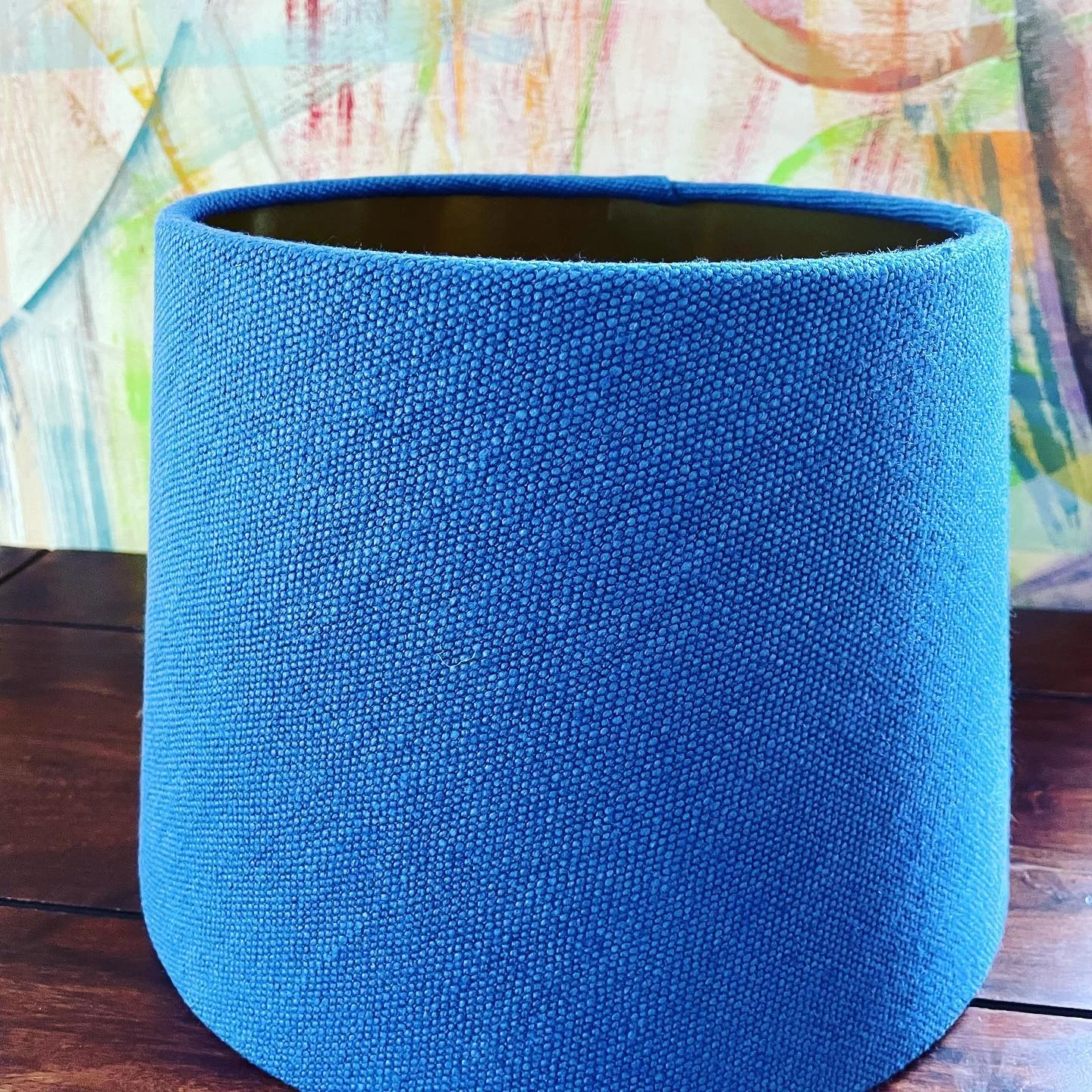 Blauer konischer Lampenschirm aus grobem Stoff auf Holztisch