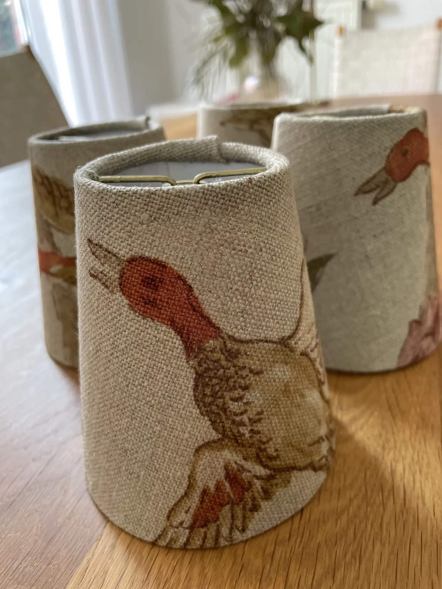 Drei kleine Lampenschirme aus Leinen mit Entenmuster auf einem Holztisch