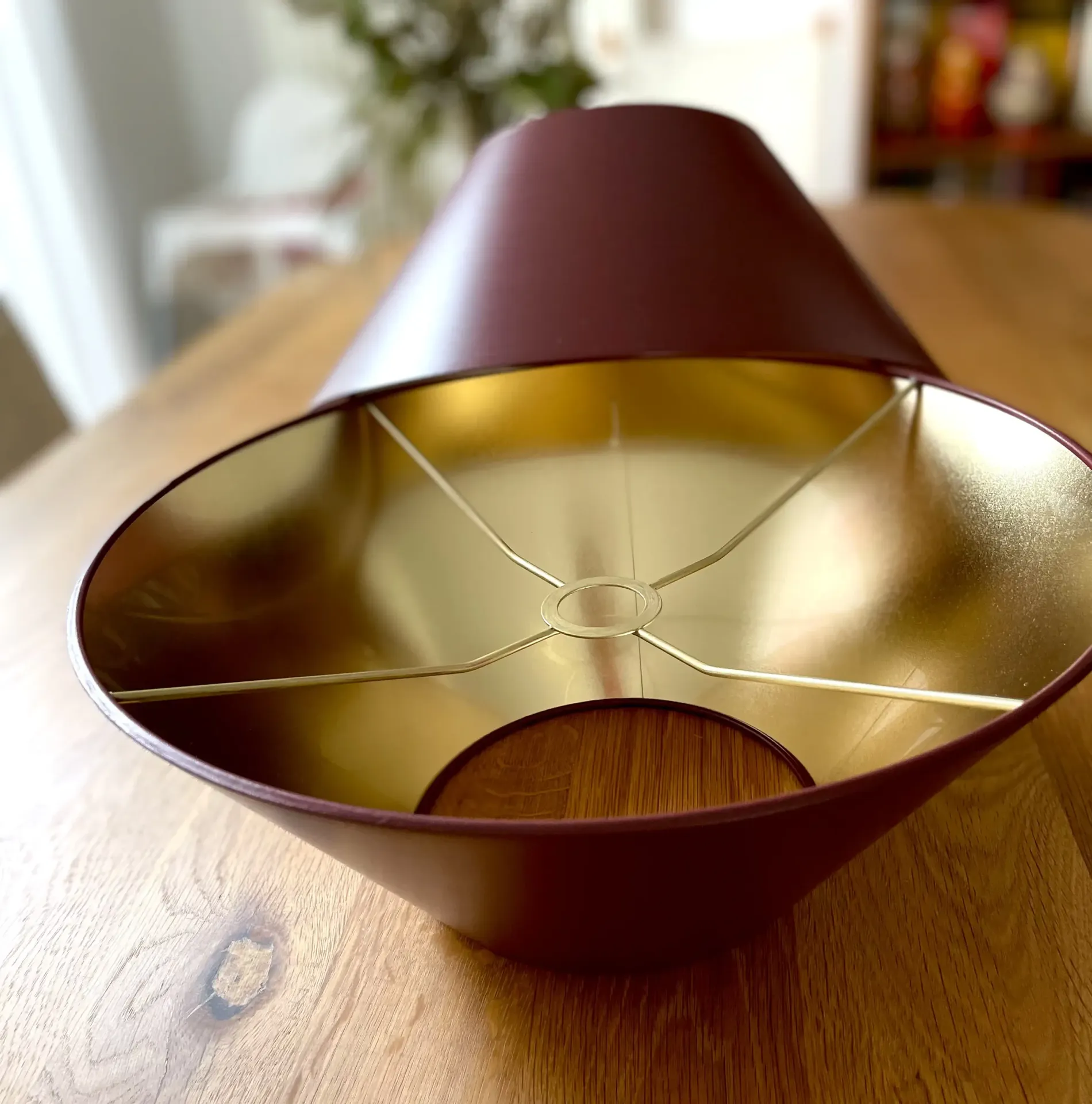 Rotbrauner Lampenschirm für Tischlampe mit goldfarbener Innenbeschichtung auf Holztisch