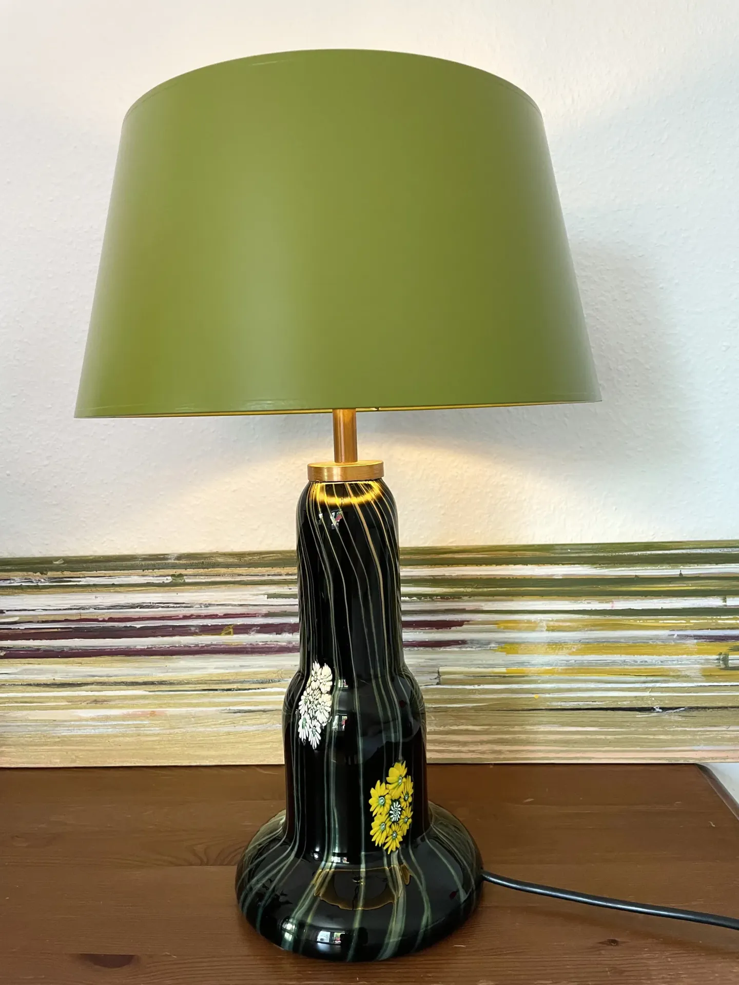 Tischlampe mit olivgrünem Schirm und schwarz-gestreiftem Keramikfuß mit Blumenmotiv