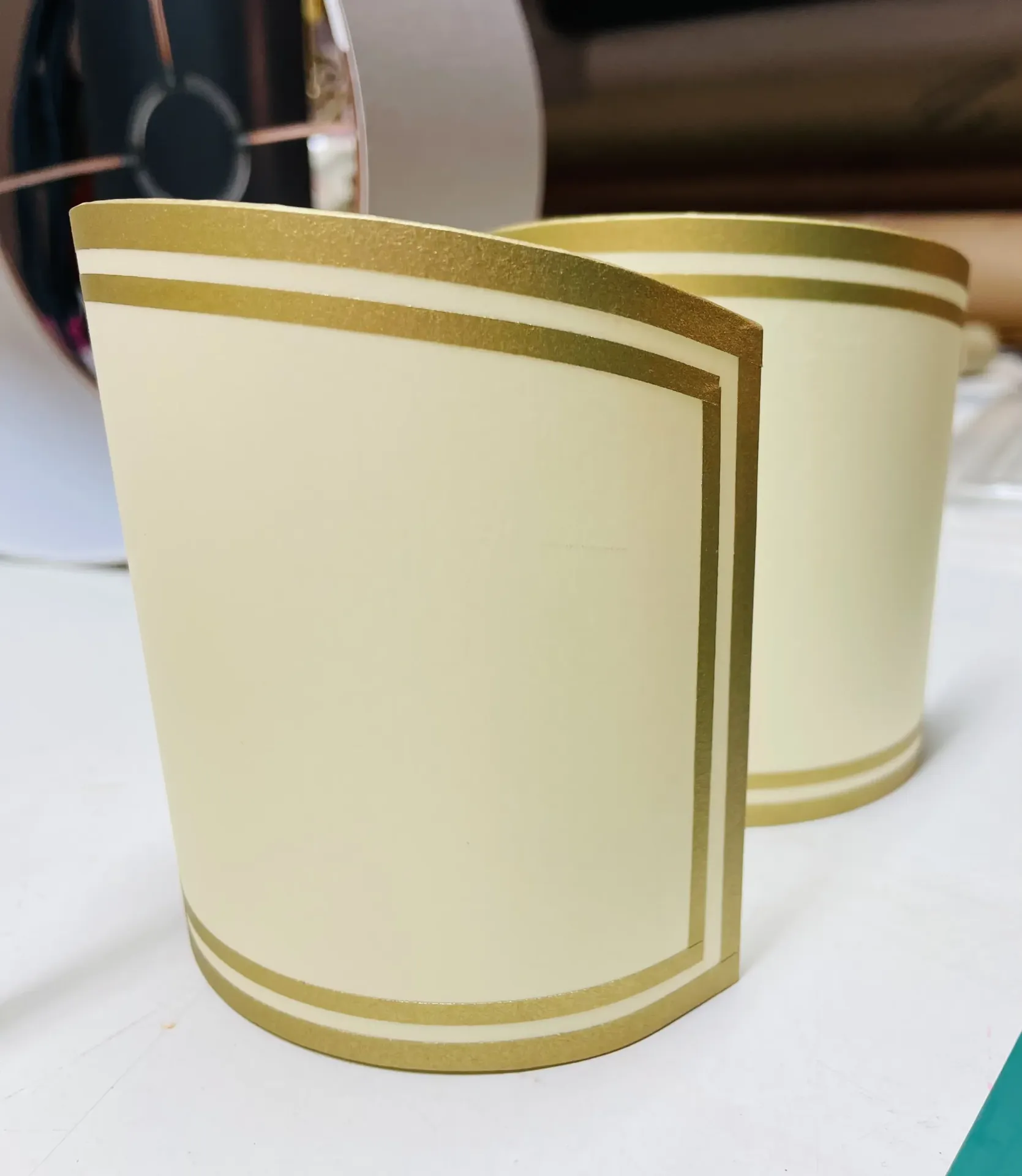 Zwei cremefarbene Lampenschirme mit goldenen Zierstreifen für Tischlampen