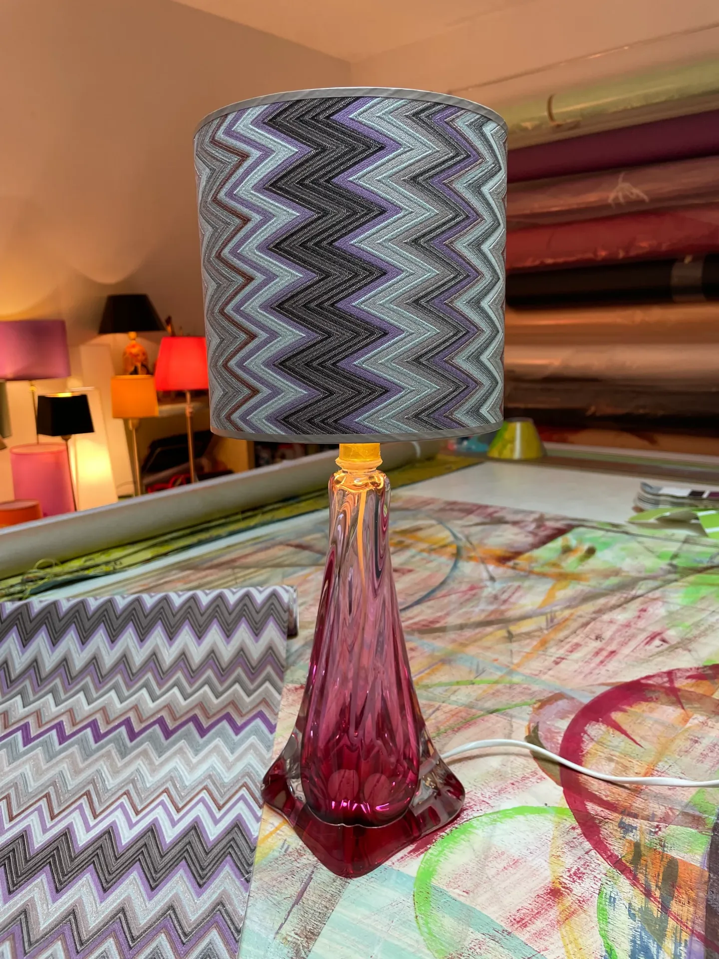 Tischlampe mit violettem Glasfuß und zickzackgemustertem Stoffschirm
