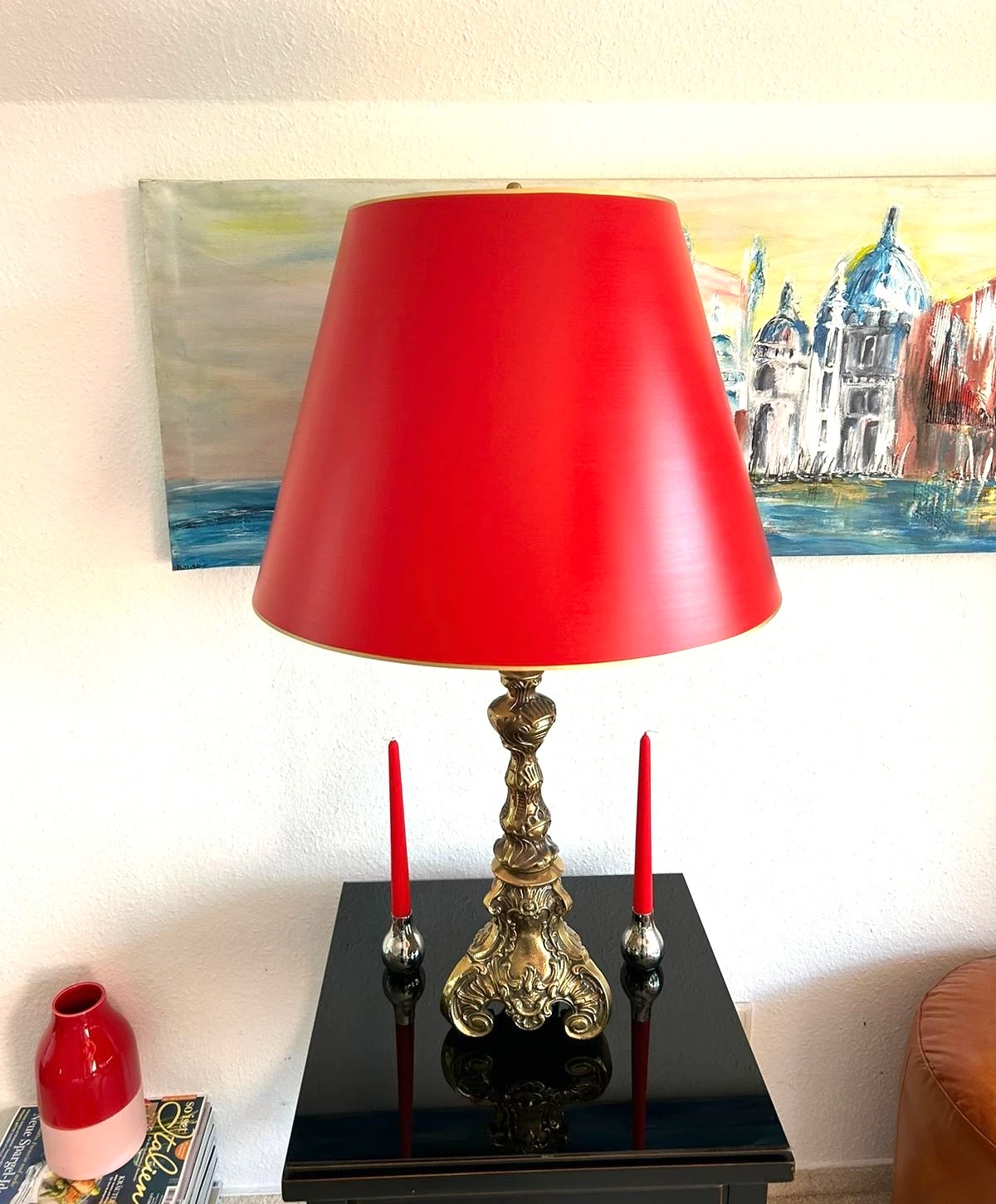 Tischlampe mit rotem Schirm und verziertem goldfarbenem Fuß, zwei roten Kerzen