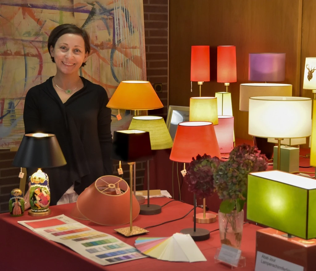 Marina Hummel hinter ihrem Ausstellungstisch mit bunten Lampenschirmen